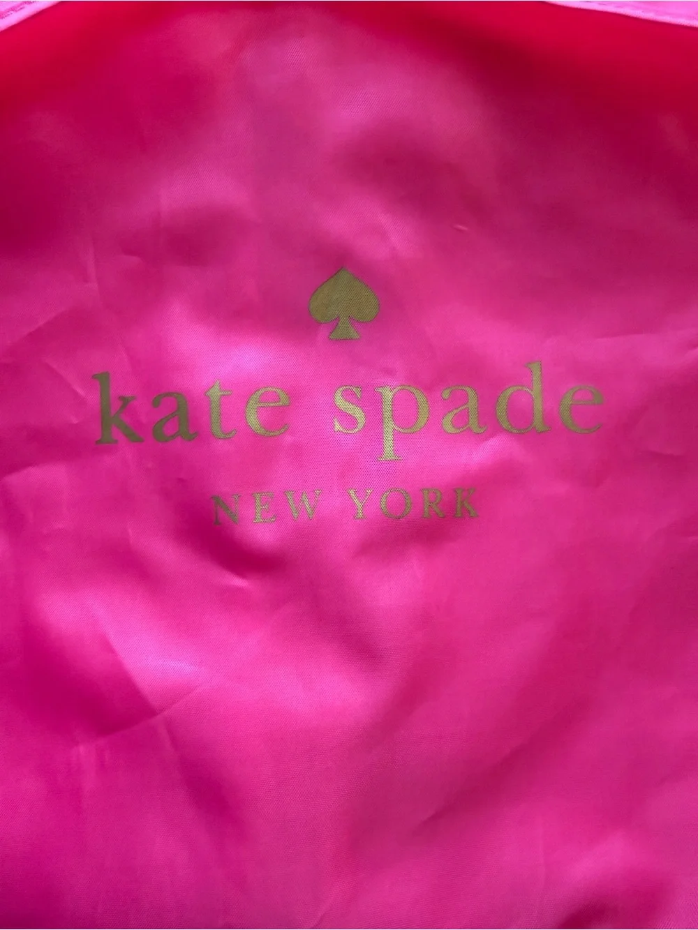 kate spade hot pink garment bag with gold logo